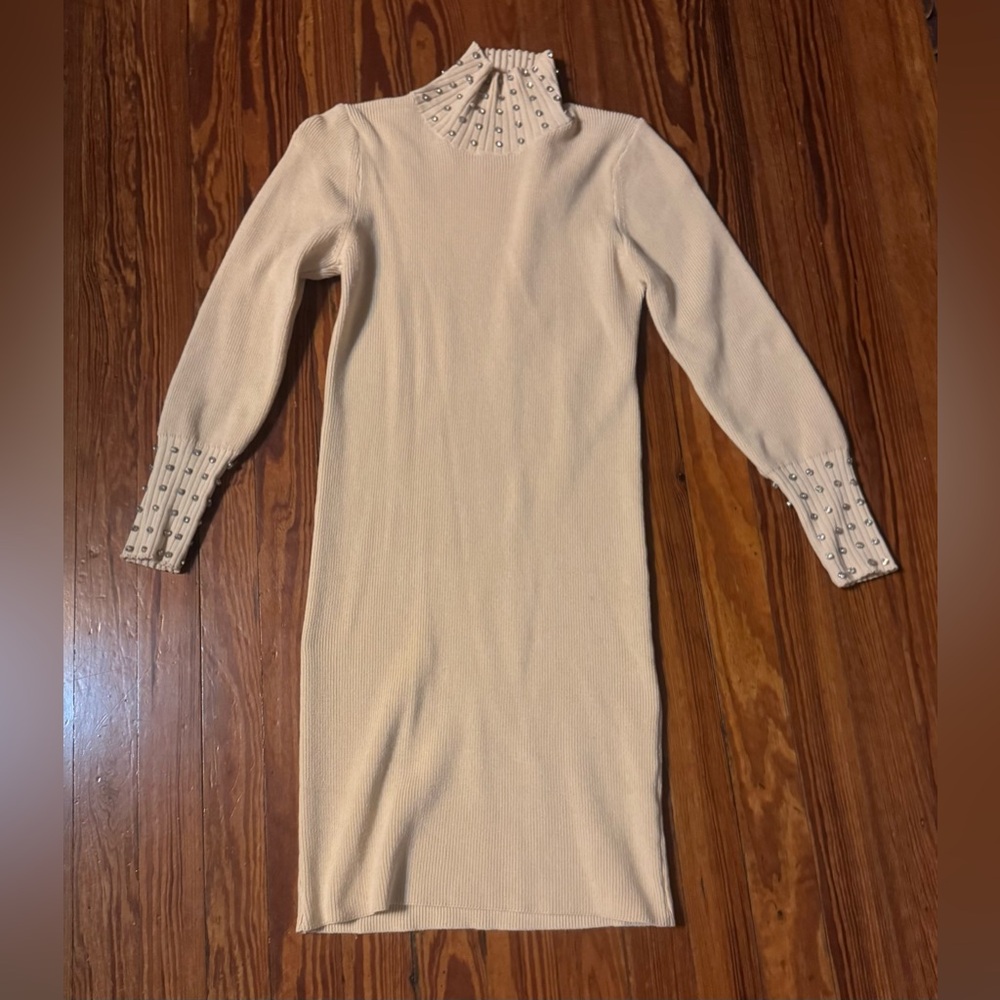 Cream or ivory ribbed knit sweater dress with a mock neck and beaded details on